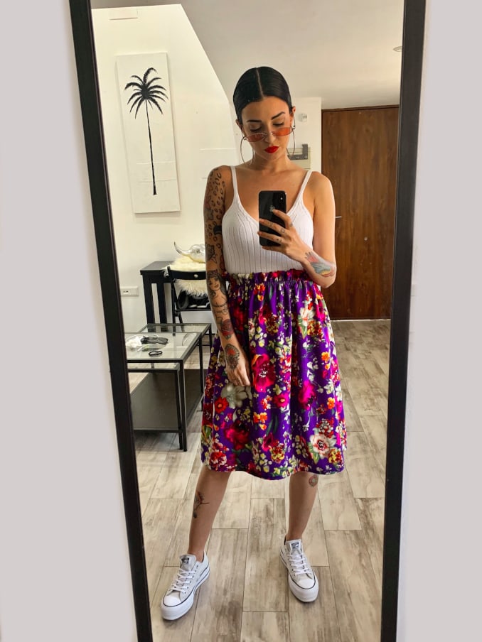 Influencer con look de falda y zapatillas Converse All Star